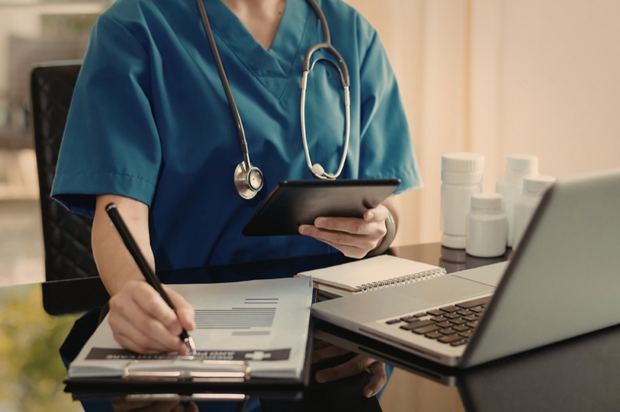 Health care professional reviewing notes with a tablet
